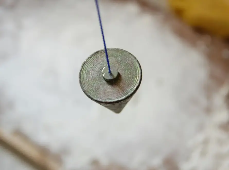 Mano sosteniendo un péndulo durante una consulta, calibración de sí y no